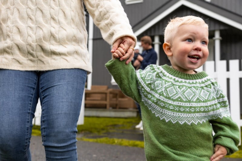 Blid gutt med grønn genser som holder mammaen sin i hånden