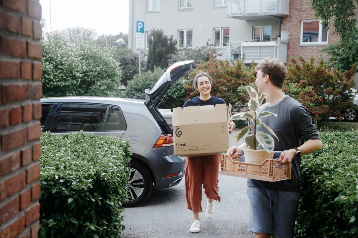 Mann og kvinne bærer esker inn i et hus
