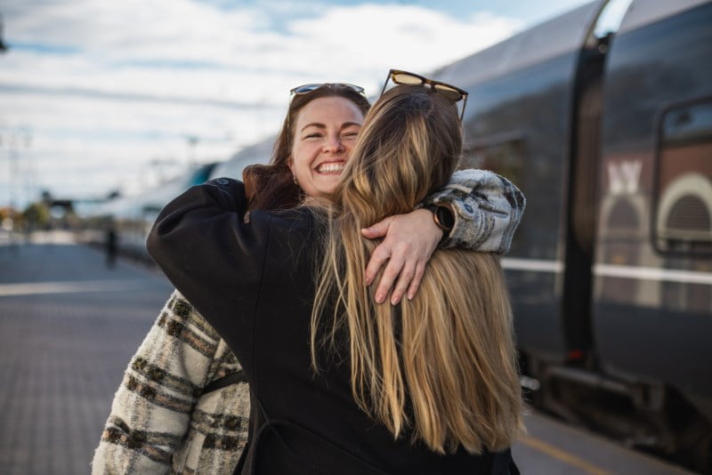To kvinner klemmer på perrongen foran et tog