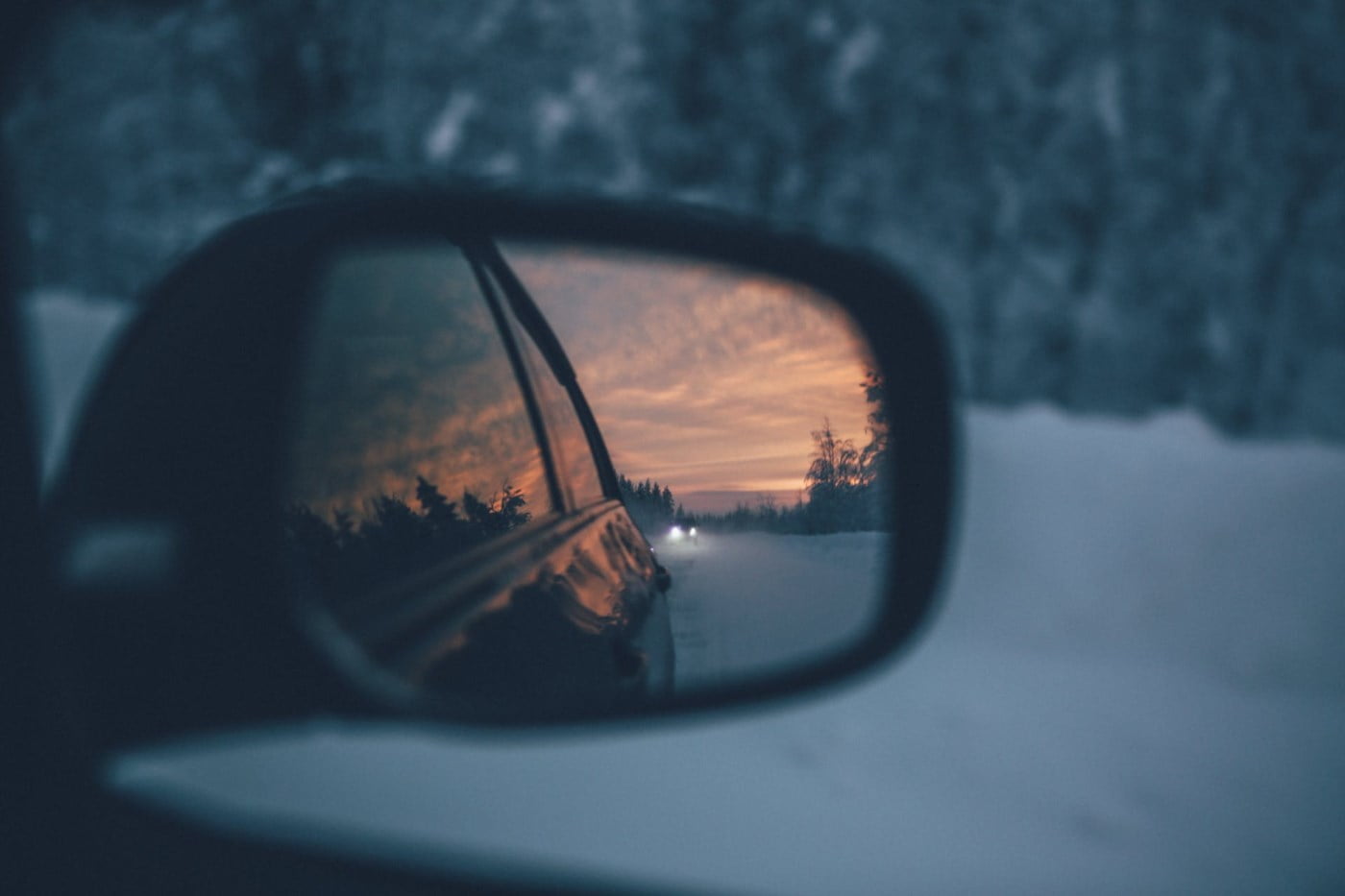 Et bilspeil reflekterer et vinterlandskap