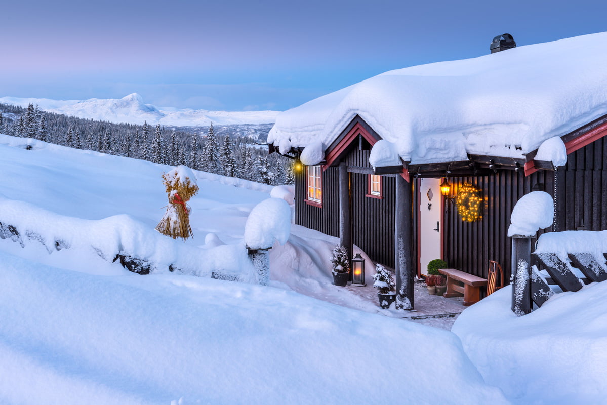 En hytte på fjellet dekket av snø