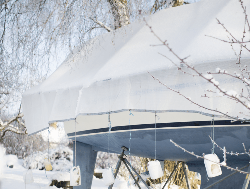 En båt er lagret om vinteren med presenning over seg