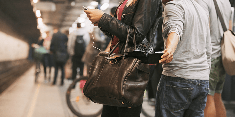 En lommetyv stjeler en lommebok fra en kvinne som står på togstasjonen, helt opptatt av å se på mobilen